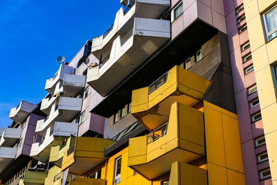 Low angle view of colourful apartment building against a blue sky