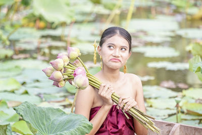 Beautiful woman holding lotus water lilies on lake