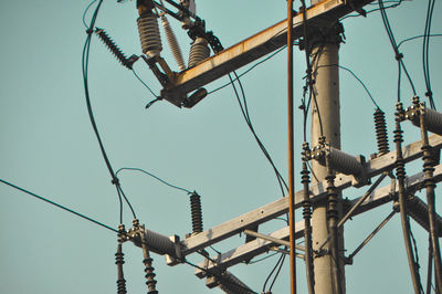 Low angle view of electricity pylon against clear sky