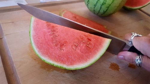 Close-up of hand holding fruit on table