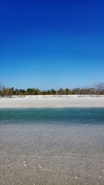 Scenic view of lake against clear blue sky