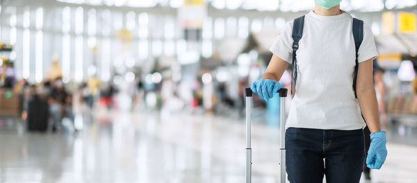 Midsection of woman with mask in airport