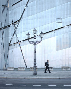 Man walking on street against buildings in city