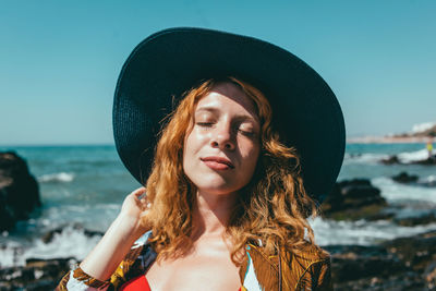 Portrait of young woman wearing hat at beach