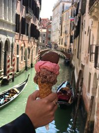 Midsection of woman holding ice cream in city