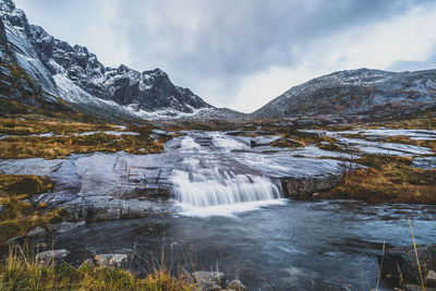 Scenic view of waterfall against sky during winter