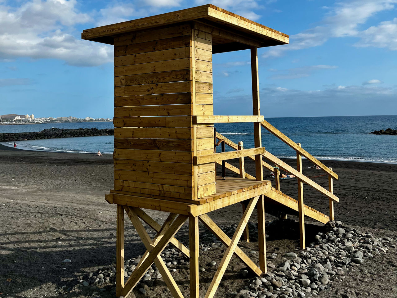 sea, water, beach, sky, land, lifeguard hut, nature, hut, cloud, architecture, man made structure, horizon over water, sand, scenics - nature, horizon, built structure, lifeguard, protection, security, wood, coast, beauty in nature, tranquility, tower, no people, day, tranquil scene, ocean, travel destinations, coastline, outdoors, observation point, shore, holiday, vacation, trip, lookout tower, non-urban scene, summer, building exterior, travel, idyllic, environment