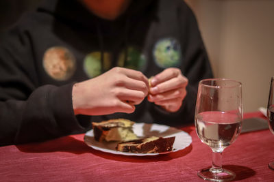 Midsection of teenage girl having food and drink at table