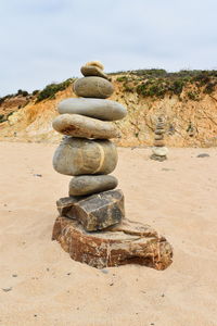 Stack of stones on beach against sky