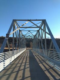 View of footbridge against clear blue sky