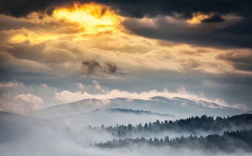 Scenic view of mountains against cloudy sky