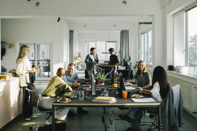 Multiracial male and female business colleagues communicating with each other at office