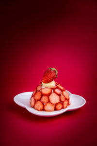 Close-up of dessert on table against red background