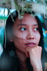 Close-up portrait of a young woman looking away