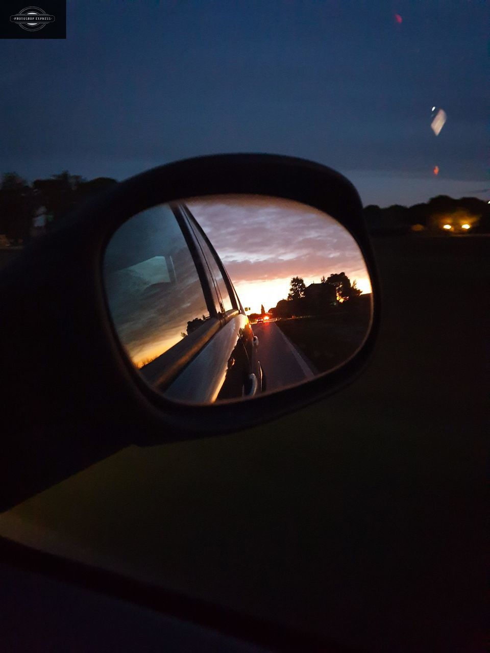 REFLECTION OF SUNSET IN SIDE-VIEW MIRROR
