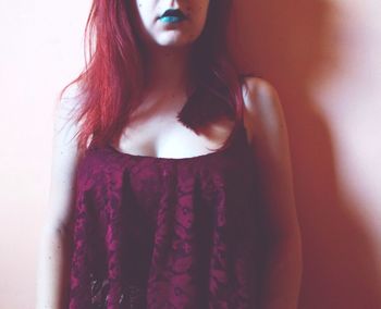 Close-up of young woman standing against white background