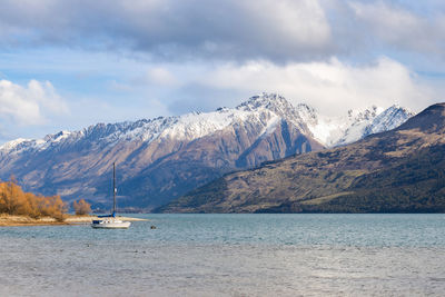 Scenic view of sea and snowcapped mountains against sky