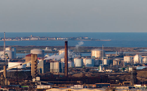 Buildings by sea against sky in city