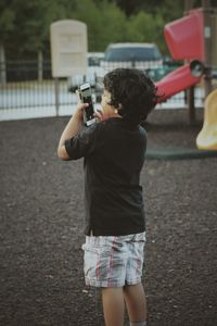 Man holding camera while standing by camera