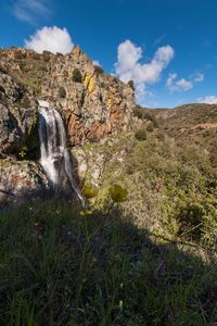 Scenic view of waterfall against sky