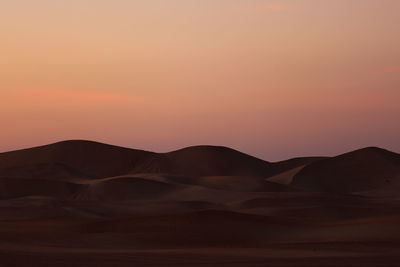 Scenic view of desert against sky during sunset