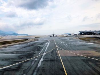 Airplane on runway against sky