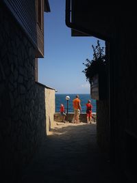 Rear view of people walking on building