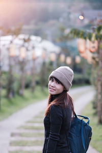 Portrait of woman standing in park during winter