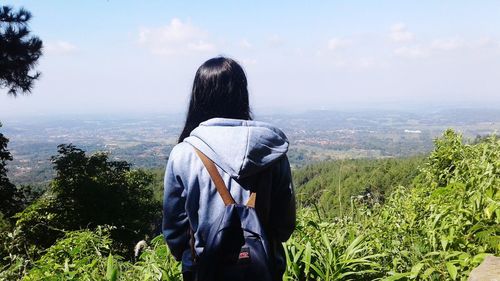 Rear view of woman looking at landscape against sky