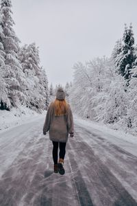 Rear view of woman walking on snow