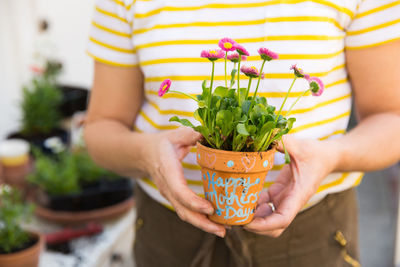 Mid section of man holding pot plant