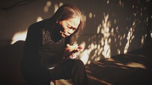 Woman eating ice cream sitting outdoors