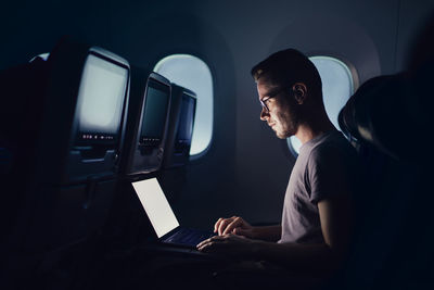 Side view of man using laptop