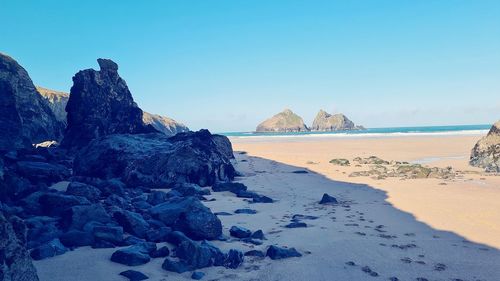 Rock formation on beach against sky