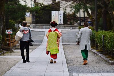 Rear view of geisha on footpath