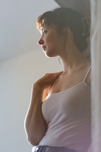 Low angle view of woman looking away while standing at home