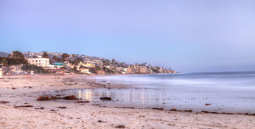 Scenic view of beach against clear blue sky