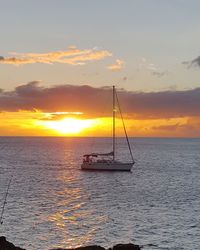 Sailboat in sea at sunset