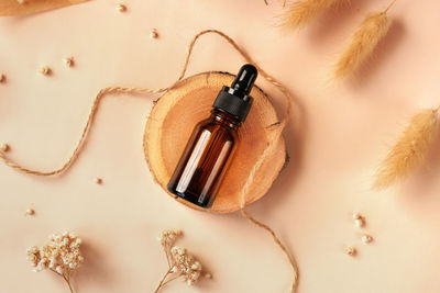 Glass amber bottle with black cap flat lay. diy scene. beauty products packaging scene. dropper