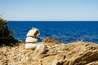 Rocks on beach against clear sky