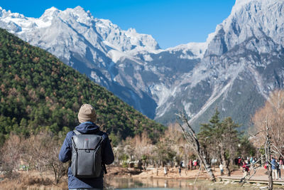 Rear view of people walking on mountain road