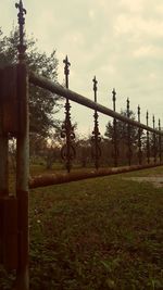 Metal fence against sky during sunset