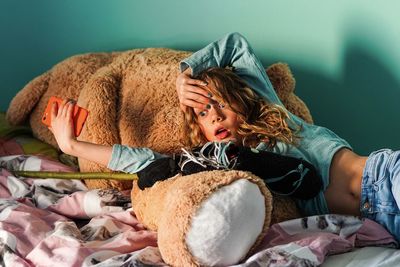 Surprised girl lying on teddy bear