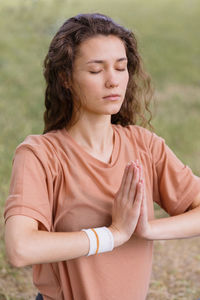 Woman with eyes closed practicing yoga at park