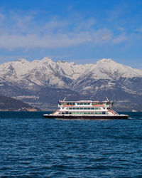 Scenic view of sea and snowcapped mountains against sky