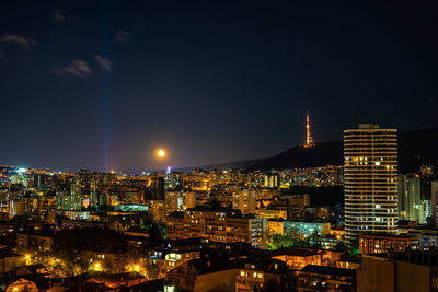 High angle view of illuminated buildings against sky at night