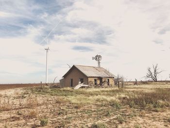 Abandoned house on field against sky