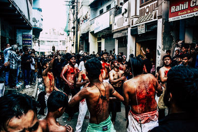 People on street against buildings in city