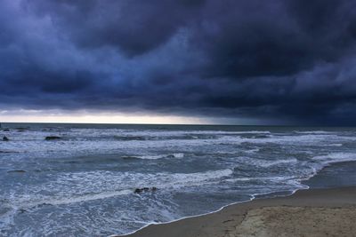 Scenic view of sea against storm clouds