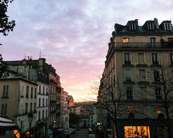 Buildings in city against cloudy sky